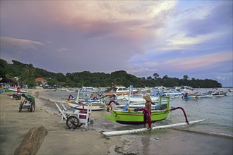 Balinese fishermen with traditional outrigger fishing boats in the bay of Padang Bai, Padangbai,