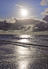 Outgoing tidal fringe in the mudflat landscape with dramatic clouds, North Sea, Norderney Island,