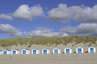 Row of blue and white beach cabins on Texel, West Frisian Island in the Wadden Sea, Noord-Holland,