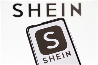 Shein logo online marketplace online trading ecommerce on a mobile phone and computer screen