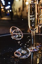 Golden rings falling into glass with wine, AI generated