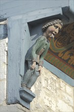 Wood carving with figure on the historic half-timbered house Bracken, tongue, sticking out,