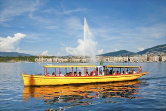 The Jet d'eau, and the Mouettes genevoises in sunshine and blue sky, landmark in the Geneva harbour