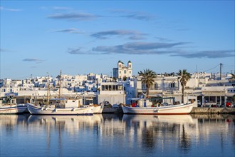 View of Naoussa, Fishing boats in the harbour at sunset, reflected in the sea, White Cycladic