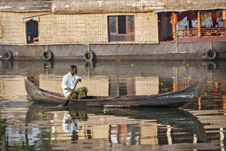 KERALA, INDIA, MAY 5, 2010: Unidentified indian man in small boat in backwaters. Kerala backwaters