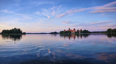 Panorama of Trakai Island Castle in lake Galve, Lithuania on sunset with dramatic sky reflecting in