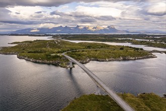 Road with bridge over Inse, behind the mountain range Seven Sisters, Herøy island, Helgeland coast,