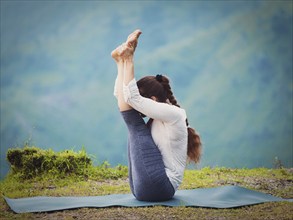 Yoga, sporty fit woman practices Ashtanga Vinyasa yoga asana Urdhva mukha paschimottanasana, upward