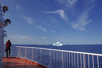 Man standing at the railing of a passenger ferry, icebergs, icebergs, Ilulissat, Disko Bay,