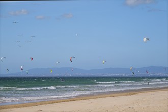 Kiteboarding kitesurfing kiteboarder kitesurfer kites on the Atlantic ocean beach at Fonte da Telha