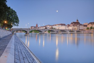 View of the old town of Basel illuminated at night with the Basel Cathedral, St. Martin's Church,