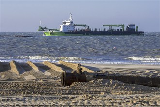 DEME trailing suction hopper dredger Uilenspiegel at sea, used for sand replenishment, beach