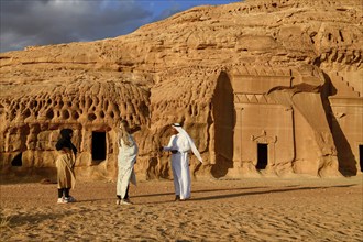 Tourists in front of the Nabataean tombs at the rock Qasr Al-Bint, Hegra or Mada'in Salih, AlUla