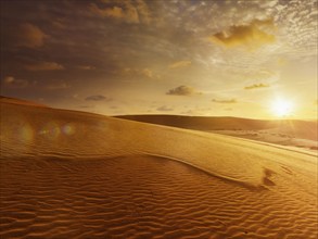 White sand dunes on sunrise, Mui Ne, Vietnam. With lens flare and light leak