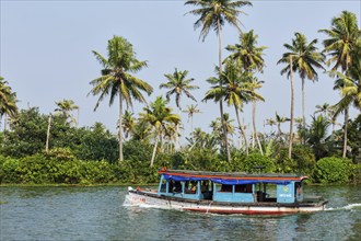 KERALA, INDIA, MAY 5, 2010: Unidentified indian people in small boat in backwaters. Kerala