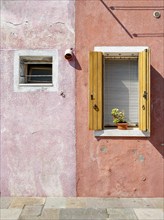 Red and pink house facade with windows, colourful houses on the island of Burano, Venice, Veneto,