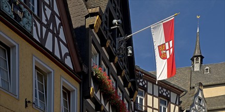 Half-timbered houses and flag with town coat of arms on the market square, Cochem,