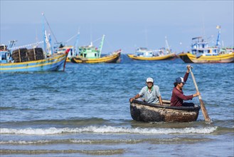 PHAN THIET, VIETNAM, 5 JUNE, 2011: Two fishermen in a coracle boat returning from fishing. Phan