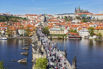 PRAGUE, CZECH REPUBLIC, APRIL 26, 2012: Charles Bridge over Vltava river crowded with tourists in