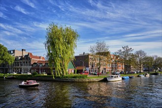 HAARLEM, NETHERLANDS, MAY 6, 2017: Boat in canal and houses. Harlem, Netherlands