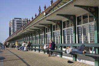 People sunning under the Paravang, windscreen with benches at Blankenberge, Belgium, Europe