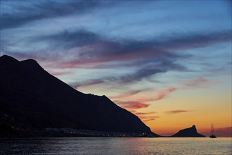 Blue evening sky, pink illuminated clouds, rocky coast, sunset, dusk, lanterns, sailboat,