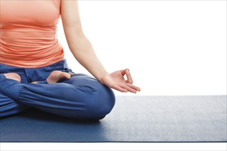 Close up of of woman in yoga asana Padmasana (Lotus pose) cross legged position for meditation with