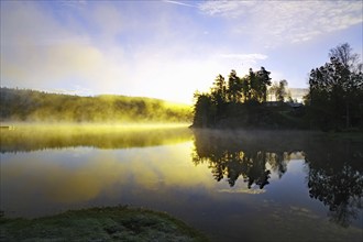 Trees reflected in the water of the Bullaren on a calm autumn morning, the first light of the day,