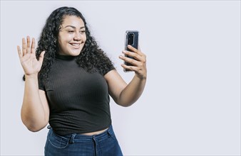 Smiling beautiful latin woman making a video call isolated. Happy Nicaraguan woman making a video