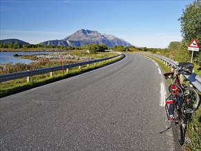 Bicycle in front of traffic sign on a narrow road warning of sheep, Mountains and Sea TJotta,