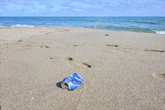 Old can, rubish lying on the sand on a beach, near Tarragona, Catalonia, Spain, Europe