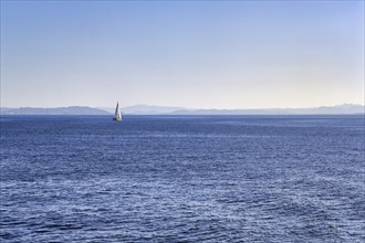 Strait, Strait of Bonifacio, sailboat in front of Sardinia Island on horizon, blue sky,