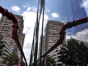 A new high-rise building is reflected in a glass façade, groundwater is pumped through pipes, new