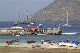 Colourful fishing boats and Creole fishermen in front of the three-masted topsail schooner