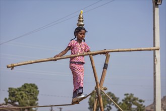 PUSHKAR, INDIA, NOVEMBER 21, 2012: Unidentified indian girl street acrobat walks the tightrope at