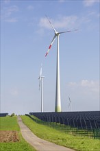 Renewable energies, solar park with wind turbines, photovoltaics, solar panels, field path,