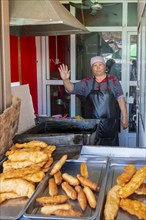 Vendor at the market stall selling pastries, Uzgen Bazaar, Ösgön, Osh region, Kyrgyzstan, Asia