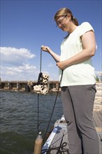 Swedish woman, 44 years old, showing a clay house for settling mussels, Frihamnen, Gothenburg,