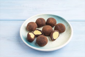 Japanese rice sweet buns chocolate mochi filled with cream on blue wooden background. side view,