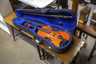 Old violin in case on display in an auction room, UK