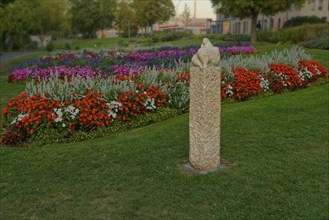 The sculpture Venus of Amberg surrounded by a colourful flower bed in the municipal park, Amberg,