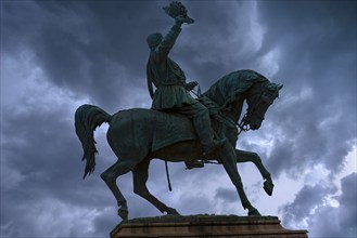 Silhouette of the equestrian statue of King Vittorio Emanuele III, rain clouds, Piazza Corvetto,