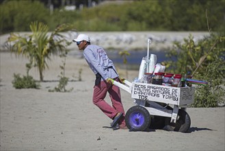 Beach vendor pulling cart with drinks at Playa Principal near Puerto Escondido, San Pedro Mixtepec,