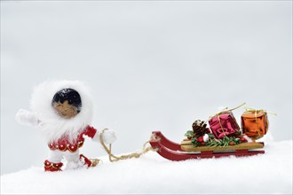 Christmas decoration, Inuit pulling sleigh with Christmas presents through the snow