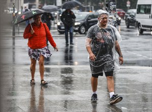 Tourists with rain capes and umbrellas during heavy rainfall, Berlin, 23 06 2023