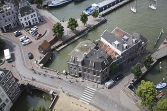 Looking down from overhead to cobbled street with cyclists, buildings and traffic, Dordrecht,