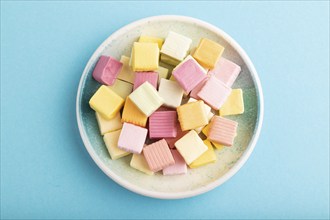 Various fruit jelly chewing candies on plate on blue pastel background. apple, banana, tangerine,