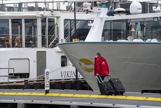 River cruise ships at the quay of the Ij, near the main railway station, passengers' luggage being