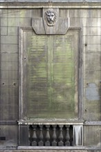 Lion's head above an emission-soiled window of an abandoned palazzo, historic centre, Genoa, Italy,