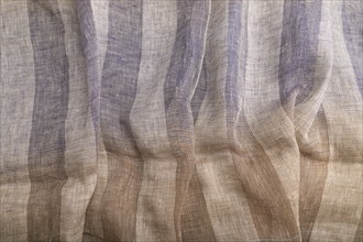 Fragment of brown and violet linen tissue. Top view, natural textile background and texture. wave